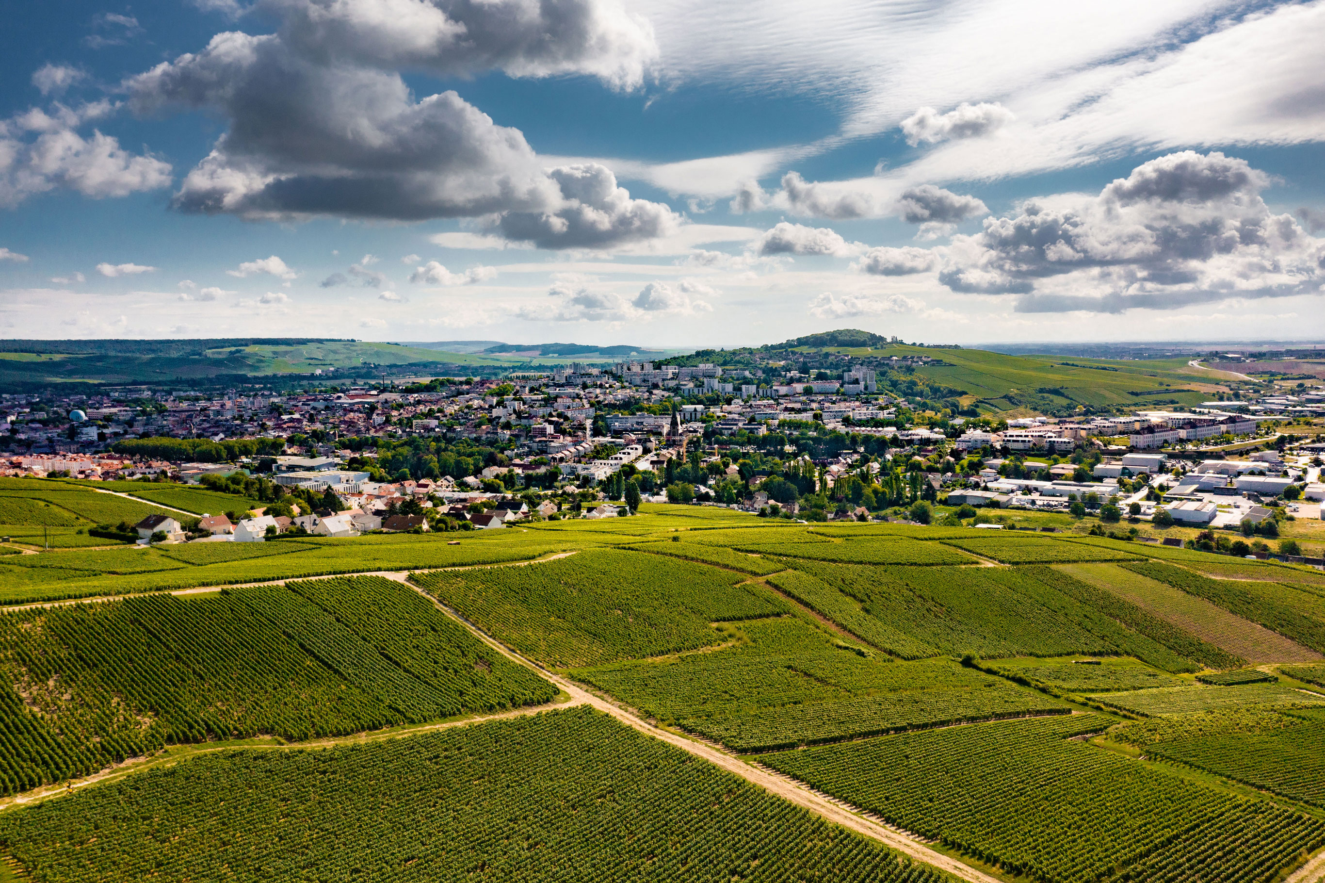 Vue aérienne : La capitale du Champagne au cœur de ses paysages de vignes - @Noémie Cozette - Ville d'Epernay